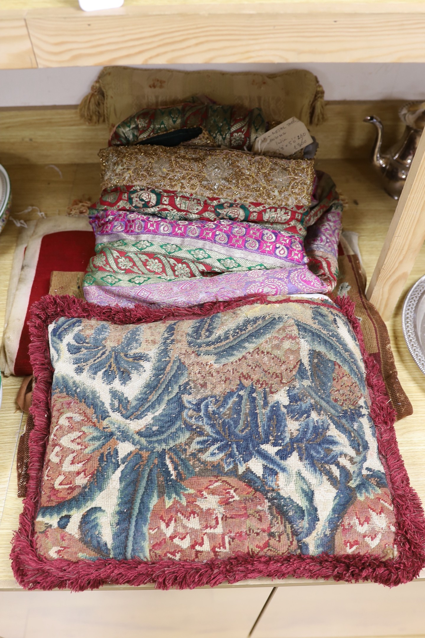 A French 18th century woolwork cushion, 2 chair covers, another panel, a tasselled brocade cushion and an Indian metallic brocaded patchworked cover